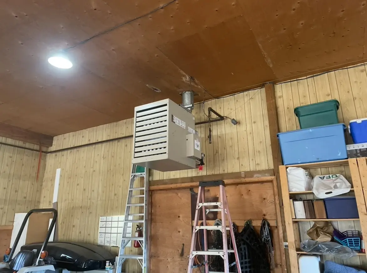 Tim and Ben servicing commercial unit heater in Calgary workspace